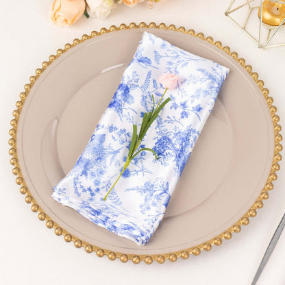 Blue floral napkin on a beige plate with a pink flower accent.