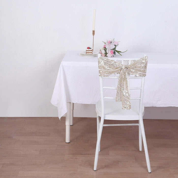Elegant white chair with a sequin bow at a beautifully set dining table.
