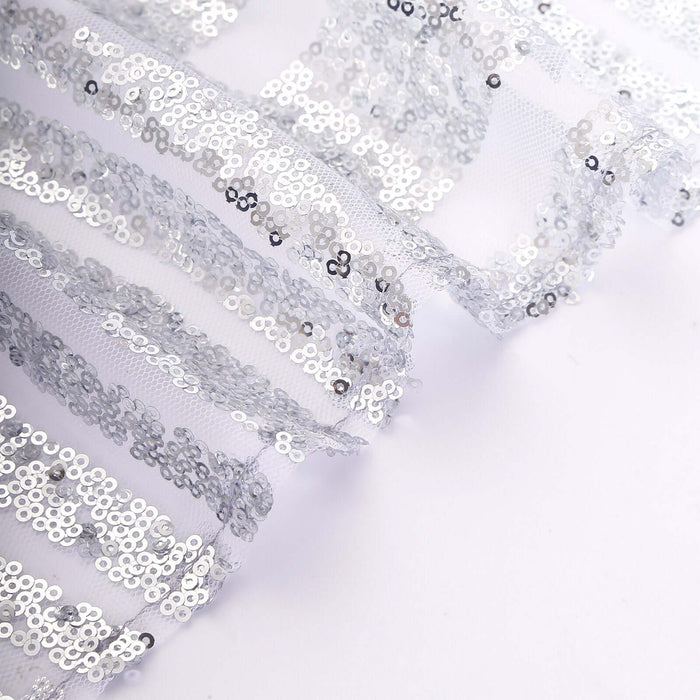 Silver sequin fabric with sheer layers for crafting and decoration.