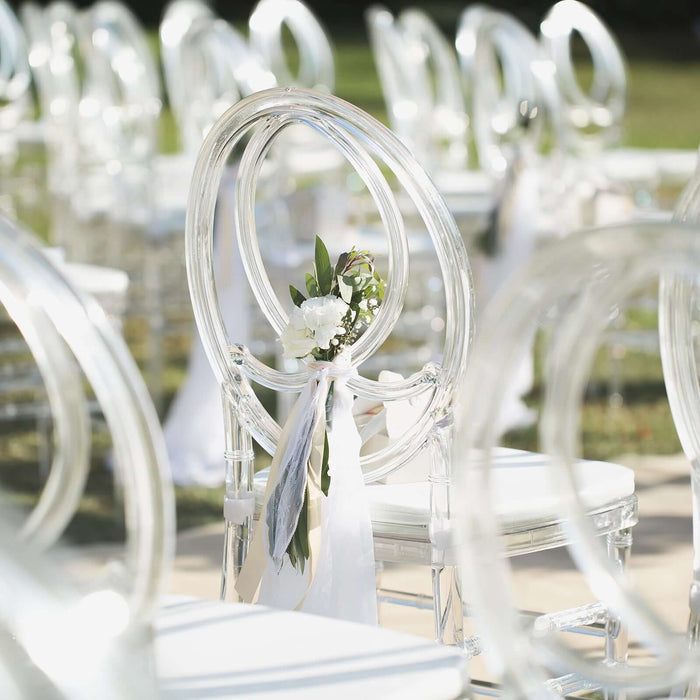 Clear acrylic chair with floral decoration for outdoor event seating.