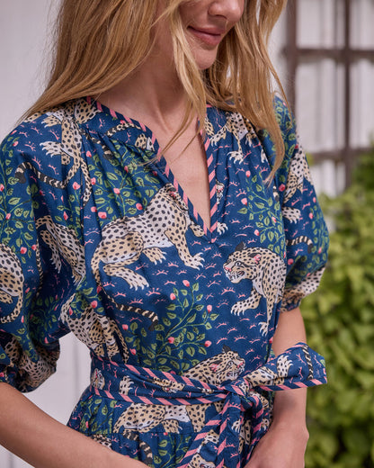 Close view of the Bagheera dress showing its V-neckline, leopard-and-floral print, puff sleeve, and tied waist belt.