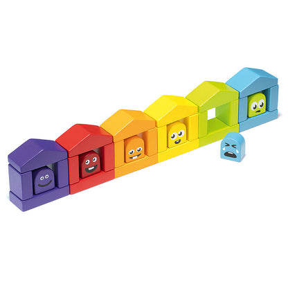 The Cubika Wooden Construction Set Colorful Houses by Cubika showcases vibrant wooden houses with emotion faces in a rainbow pattern; one blue house with a sad face stands apart from the rest.