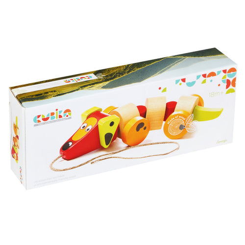 A rectangular box showcases the Cubika Wooden Sausage Dog pull toy in red, yellow, and natural wood. The eco-friendly packaging displays the Cubika brand and notes it's suitable for children aged 18 months and up.