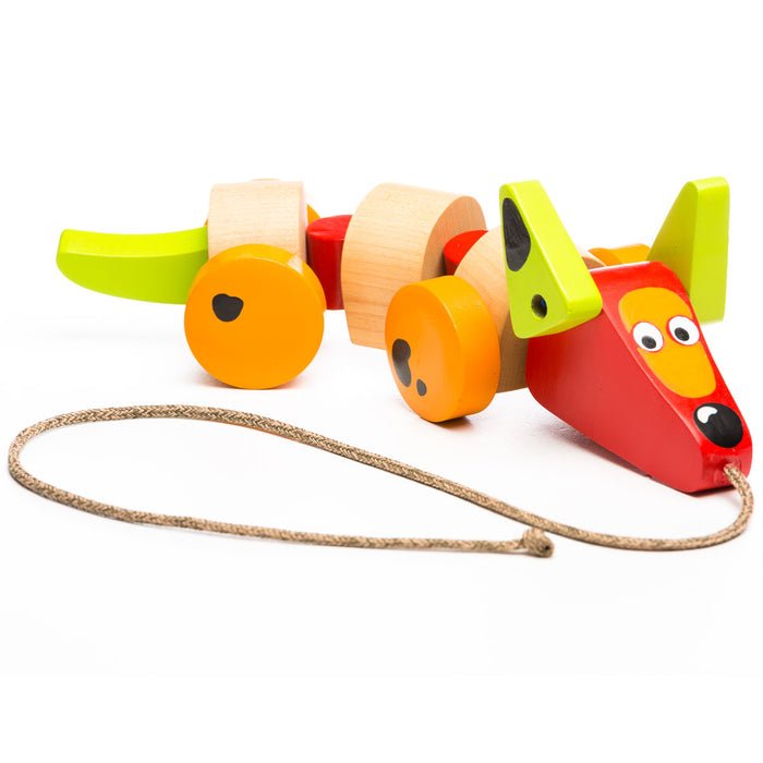 The Cubika Wooden Sausage Dog by Cubika is a colorful wooden pull toy with orange and yellow wheels, a green tail, large eyes, and a red snout. This eco-friendly toy encourages toddler balance and active play.