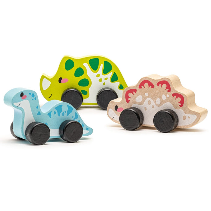 The Cubika Wooden Toy Set Joyful Dinos includes three eco-friendly wooden dinosaurs on wheels—a blue and white sauropod, green and yellow stegosaurus, and beige and red dino—perfect for imaginative play.