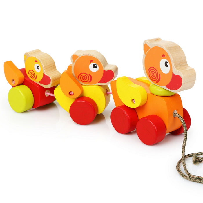 The Cubika Wooden Walk-A-Long Traveling Ducks by Cubika features three colorful wooden duck figures on wheels, connected with a string for pulling. This charming toddler toy encourages balance and coordination with its vibrant painted details.