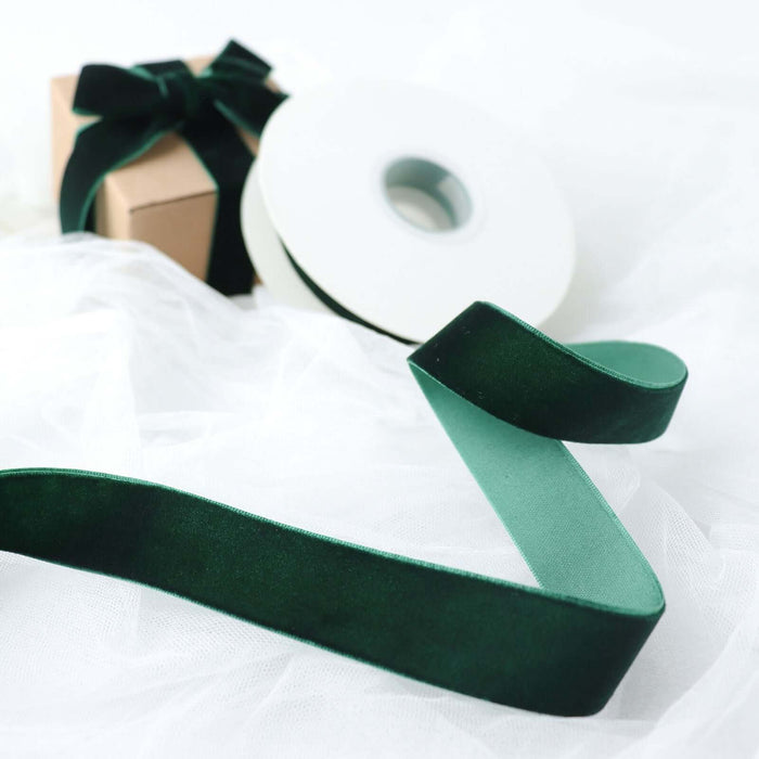 Elegant green velvet ribbon on a spool with a gift box.