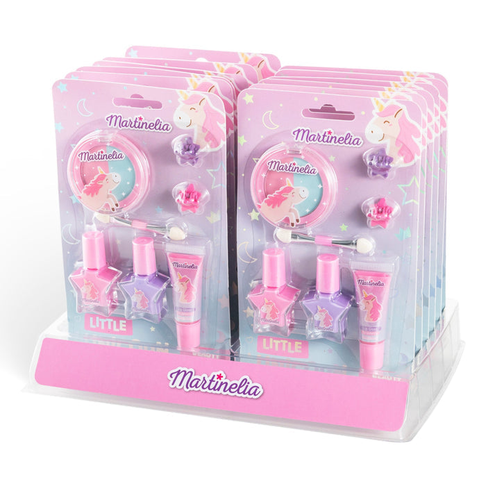 Martinelia's "Little Unicorn Beauty Basics" kid-friendly makeup sets feature pink, purple, and pastel nail polish, lip gloss, and accessories in unicorn-themed packaging. The sets are neatly arranged on a clear display stand.