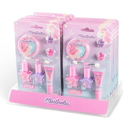 Martinelia's "Little Unicorn Beauty Basics" kid-friendly makeup sets feature pink, purple, and pastel nail polish, lip gloss, and accessories in unicorn-themed packaging. The sets are neatly arranged on a clear display stand.