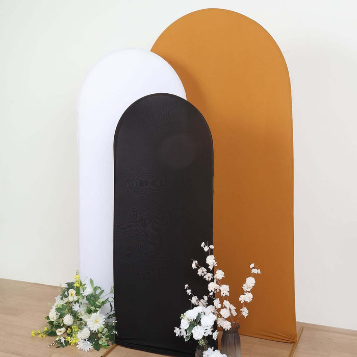 Three curved backdrops in white, black, and gold with flowers in front.