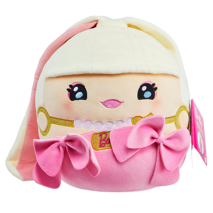 The Mattel Barbie Cutopia 10in Plush by Mattel is a round kawaii-style plush with a smiling face, long blond hair, pink lips, pink bows, and a pink and white outfit. A tag with the Barbie logo is attached to the side.