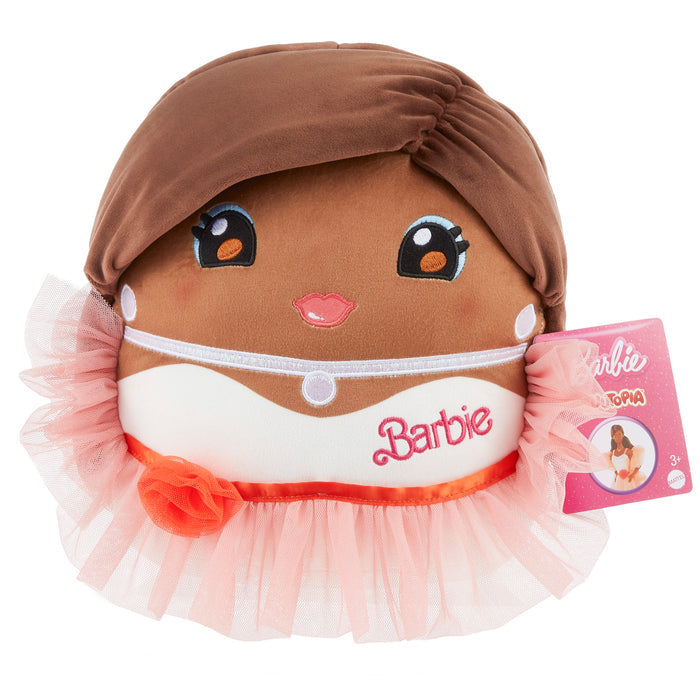 The Mattel Barbie Cutopia 10in Plush features a brown, smiling face with large eyes and pink lips, wears a pink and white tutu skirt and headband, has "Barbie" embroidered on the front in kawaii style, plus a pink tag. Brand: Mattel.