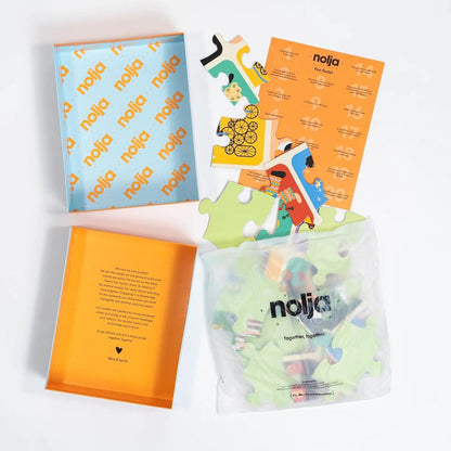 The Nolja Easy As 1,2,3 36pc Jigsaw Puzzle set is displayed open with pieces in a clear bag, an orange instruction sheet, and a blue illustrated lid featuring the Nolja brand—all neatly arranged on a white surface.