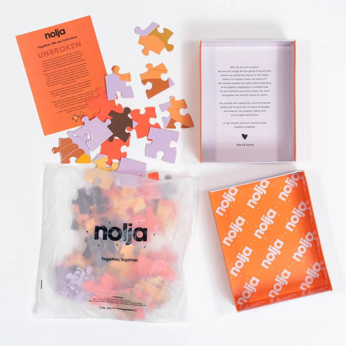 The Nolja Unbroken 64pc Jigsaw Puzzle features pink, orange, brown, and purple pieces spread on a white surface. Included are an orange box, instruction sheet, and a branded Nolja pouch for hands-on play.