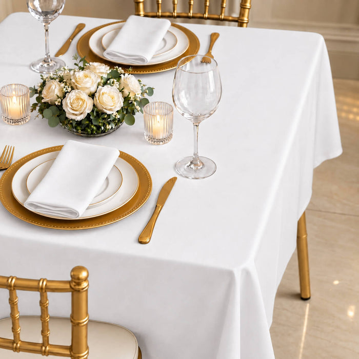 White polyester square tablecloth on a elegantly set dining table.