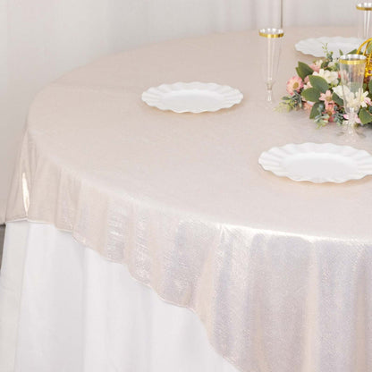 Elegant round table with shimmering beige tablecloth and white plates.