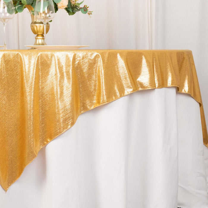 Gold tablecloth draped elegantly over a white table for a stylish event setting.