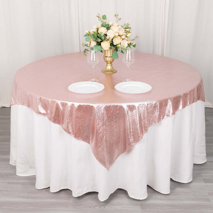 Rose gold tablecloth with elegant floral centerpiece and dinnerware.