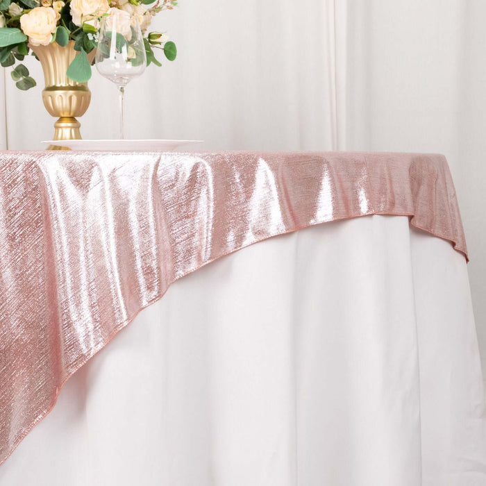 Shimmering rose gold tablecloth draped elegantly over a white table.