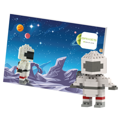 The Brixies Postcard Astronaut features a block-style astronaut figure built from micro bricks, posed before a vibrant space background with planets and stars, beside a “Brixies Build Love” sign.