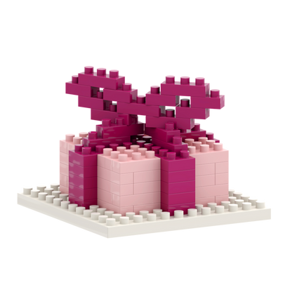 The Brixies Postcard Gift is a small 3D gift box model in pink and magenta micro bricks on a white base, with a large brick bow on top—an adorable addition to any Brixies Post Card collection.