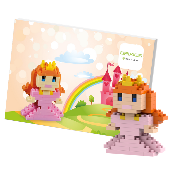 The Brixies Postcard Princess mini build kit features a 3D princess figure with a crown, standing before a colorful fairytale backdrop with a castle, rainbow, clouds, and the Brixies logo.