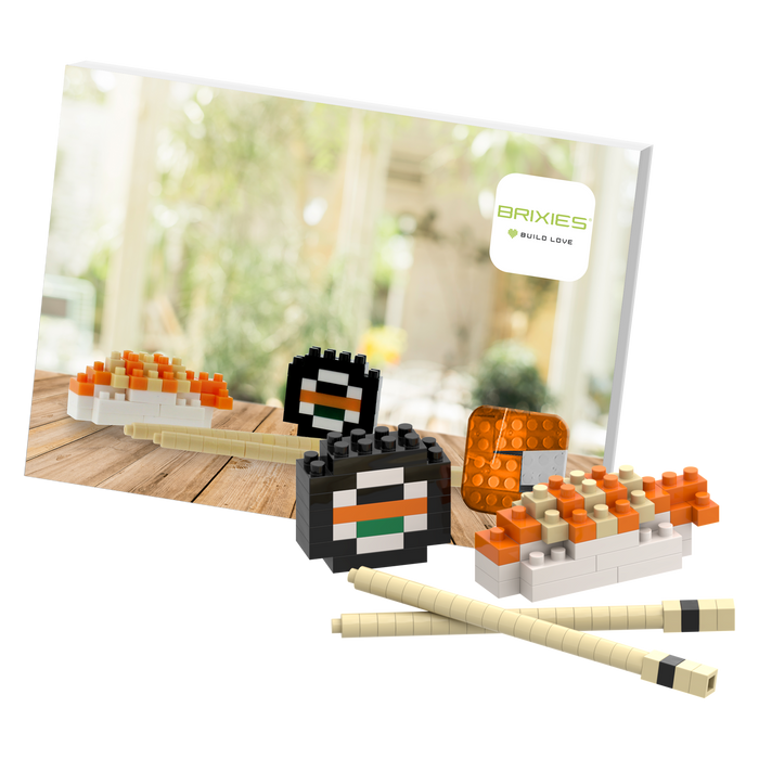 The Brixies Postcard Sushi is a small, colorful 3D sushi model built from blocks, displayed with chopsticks and a Brixies logo card—perfect as a mini build kit or unique mailable postcard gift.