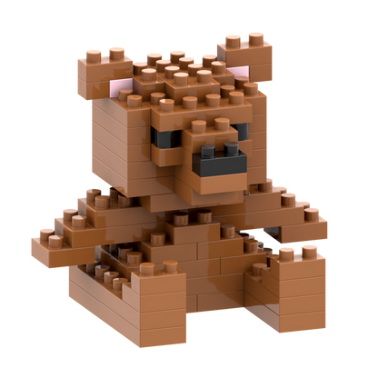 The Brixies Postcard Teddy Bear is a small brown teddy bear figure made from interlocking bricks, featuring pink ears and black eyes and nose—ideal for mini build kits or as part of the Postcard Teddy Bear collection.