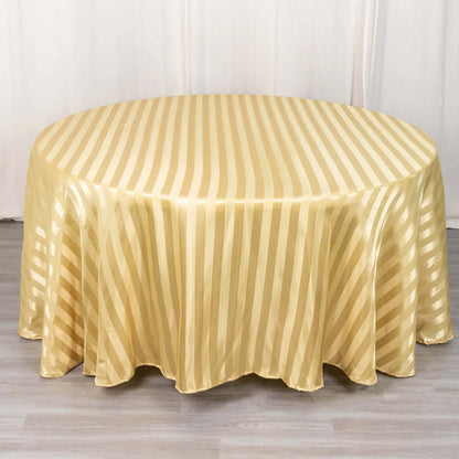 Gold striped round tablecloth on a light wooden surface.