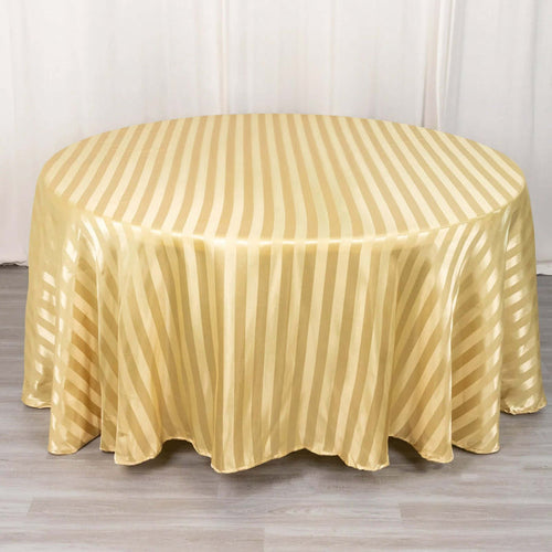 Gold striped round tablecloth on a light wooden surface.