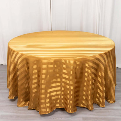 Round gold striped tablecloth on a plain backdrop.