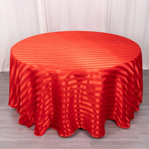 Red striped round tablecloth on a wooden table.