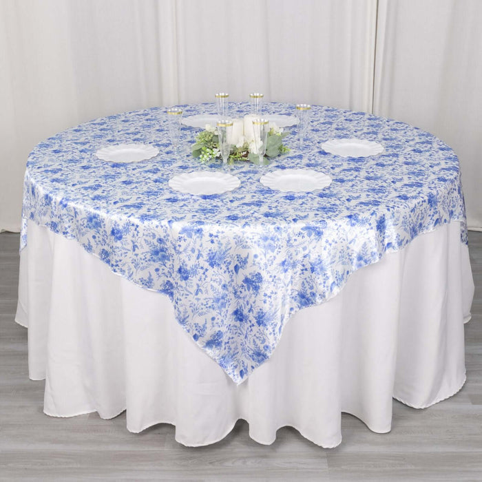 Round table covered with a blue floral tablecloth.