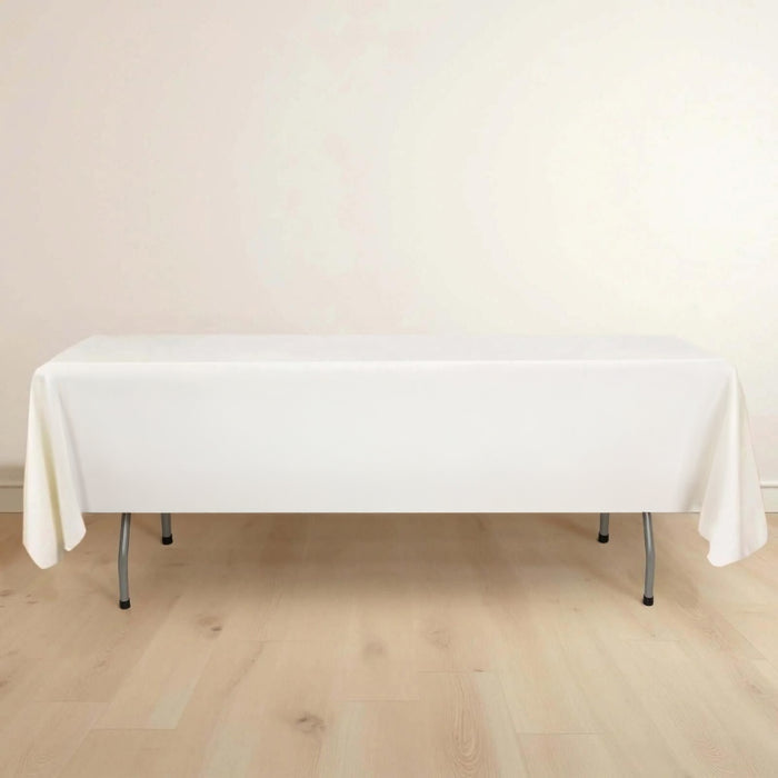 White table with a tablecloth on a light wooden floor.