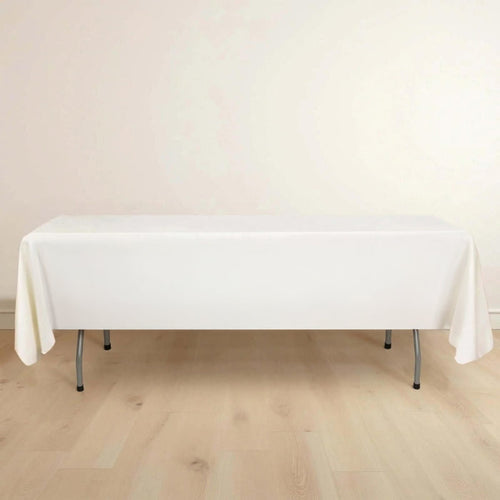 White table with a tablecloth on a light wooden floor.
