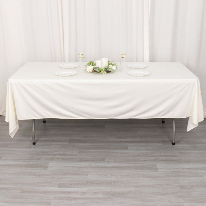 Elegant white table setup with plates and decor for formal dining.
