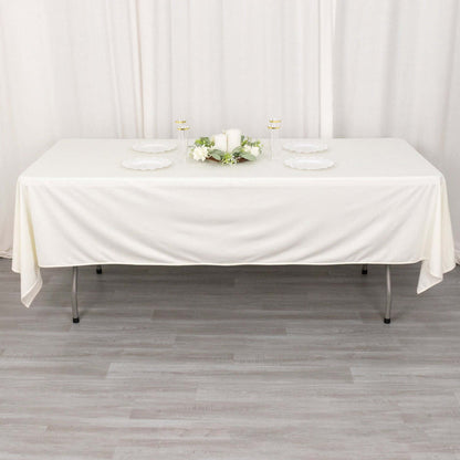 Elegant white table setup with plates and decor for formal dining.