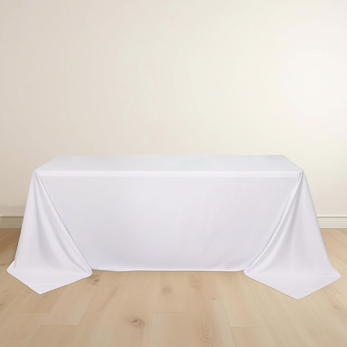 White rectangular table covered with a smooth tablecloth.