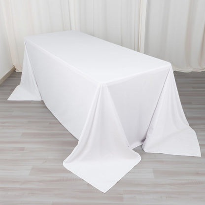 White tablecloth draped over a table on a plain backdrop