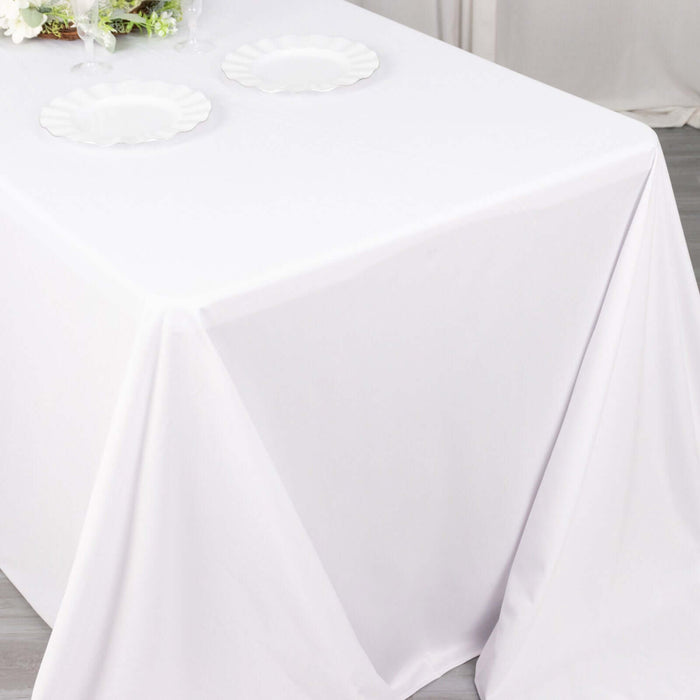 White tablecloth draped over a table with two empty plates.
