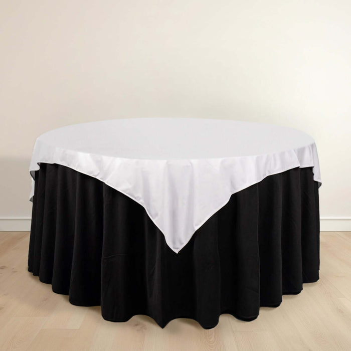 Round table with black skirt and white tablecloth.