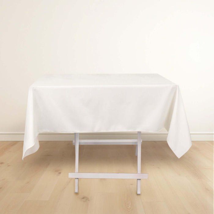 White tablecloth draped over a folding table on a plain background