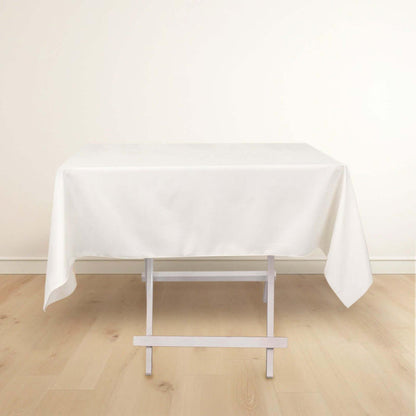 White tablecloth draped over a folding table on a plain background