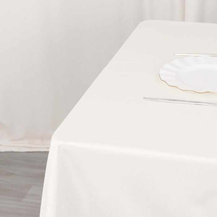 Elegant white tablecloth with plate and cutlery set for dining.
