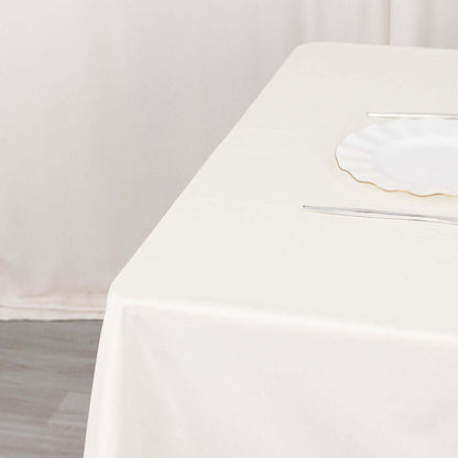Elegant white tablecloth with plate and cutlery set for dining.