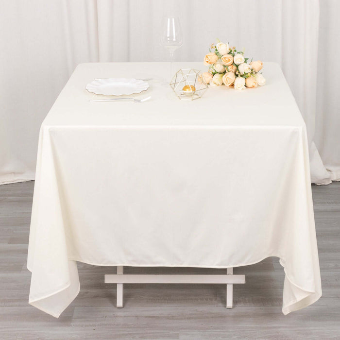 Elegant cream tablecloth draped over a white table, styled with flowers and decor.