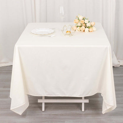Elegant cream tablecloth draped over a white table, styled with flowers and decor.