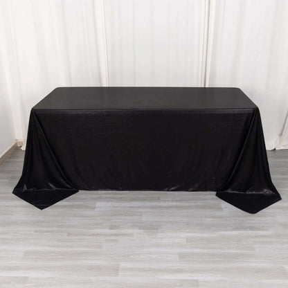 Black table draped with a sleek tablecloth for event styling.