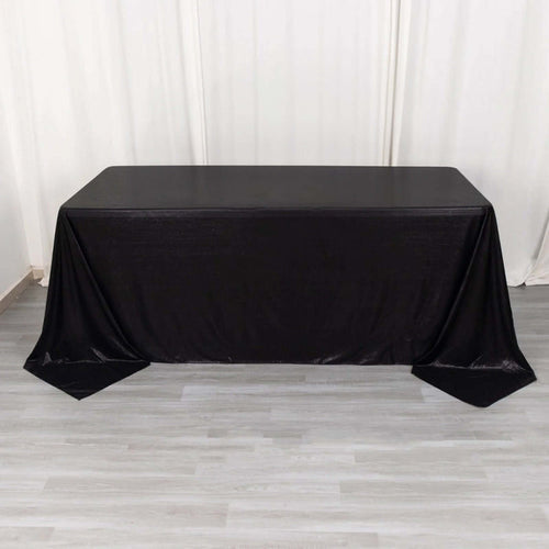 Black table draped with a sleek tablecloth for event styling.