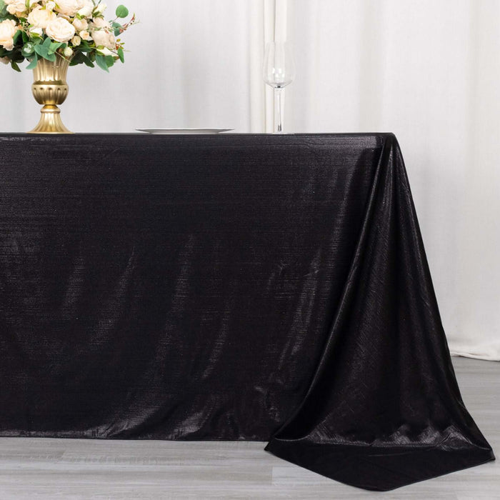 Elegant black tablecloth draped over a table with floral centerpiece.